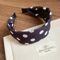Vista de detalle de una elegante diadema de tela con lunares negros y blancos de moda - Diadema de Esponja con Lunares / Negro