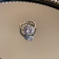 Close-up van een zilveren halo ring met ronde zirkoon op een spiegeloppervlak - Stijl 1 / Zilver