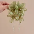 Detail showing elegant green mesh flower earrings with long crystal tassel drops. - Light Green (Silver Pin)