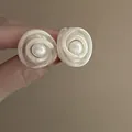Dettaglio ravvicinato di eleganti orecchini a fiore in rete crema con perla centrale - Orecchini a Bottone con Perla in Rete a Spirale 3D Bianco Crema