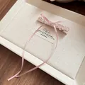 Détail d'une pince à cheveux rose en perles de verre avec un long ruban sur plateau. - Pinces à cheveux bec de canard / 1 Pièce / Rose