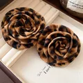 Dettaglio ravvicinato di orecchini a fiore in tessuto leopardato con ago d'argento - Stile Floreale Con Stampa Leopardata / Marrone