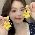 Detailed view of yellow fabric flower earrings with gold metal frame worn by model - Silver Post Style (03#) / Gold-Yellow