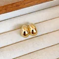 Boucles d'oreilles gouttes dorées brillantes dans un plateau à bijoux blanc texturé - Style Œuf Brillant (12#)