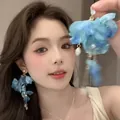 Close-up of a model wearing elegant blue fabric flower earrings with pearl dangles - Silver Post Style (04#) / Blue