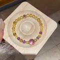 Vista dettagliata di un bracciale vintage in agata e cristallo su un vassoio di legno. - Stile 49 (Bicolore) / Giallo/Viola
