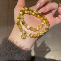 Dettaglio del bracciale vintage in agata e cristallo con Pixiu dorato e ciondolo inciso - Stile 50 (Pixiu) / Oro/Marrone