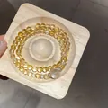 Primo piano di un bracciale a due fili in cristallo di pietra del sole gialla su legno - Stile 52 (Doppio Giro) / Giallo