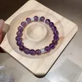Primo piano di un braccialetto di ametista viola con distanziatori argentati su legno. - Stile 20 (WB419) / Argento/Viola