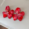 Close-up detail of red floral resin earrings with sparkling rhinestone accents for women - Red