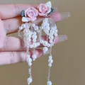 Macro view of delicate pink rose earrings with elegant white pearl bead tassels - Pink Rose Pearl Tassel Earrings