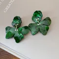 Close-up of green resin flower earrings featuring marbled texture and rhinestone accents - Green
