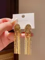 Detailed view of gold fringe tassel earrings with sparkling rhinestones on a card. - Gold - Semicircle (Style 21 Silver Post)