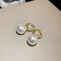 Macro detail of elegant gold-plated hoop earrings featuring pavé zircons and white pearls - Gold