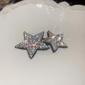 Close-up of sparkling Y2K star hair clips with iridescent rhinestones on white tray - BB Clip Star Style / Silver