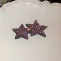 Close-up view of two shiny purple rhinestone star-shaped hair clips on a white tray - BB Clip Star Style / Purple
