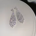 Dettaglio ravvicinato di orecchini pendenti in argento con zirconi scintillanti - Perno in Argento-Argento-Trasparente