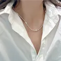 Vista dettagliata di un'elegante collana di perle e grani d'argento con camicia bianca - Collana di Perle Triangolare (44.#)