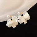 Elegant white pearl earrings featuring floral petal tassel designs, close-up shot - Silver Post Style (HE25183) / White