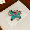Close-up of a colorful enamel horse brooch featuring intricate floral patterns and gold accents - Rocking Horse (HP973) / Green Flower