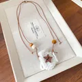 Detailed view of handmade crocheted bag pendant necklace with wooden star button and beads - Necklace-Brown-White