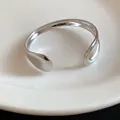 Detailed macro shot of a polished silver-tone metal water-drop open cuff bracelet. - Water Drop Shape / Silver