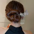 Vue détaillée d'un pic à cheveux papillon argenté avec glands fleuris dans un chignon chic - Papillon Fleur Argent