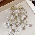 Close-up detail of elegant white floral petal tassel earrings with gold chains and pearl accents - Petal Tassel Style / Gold with Off-White