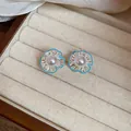 Detail view of silver flower stud earrings with blue enamel edges and center pearls in a box. - Silver Needle / Silver-Blue