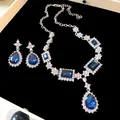 Détail rapproché d'une parure de bijoux avec pierres précieuses bleues et strass étincelants - Ensemble collier et boucles d'oreilles 2 pièces / Argent-Bleu
