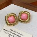 Close-up detail of vintage twisted gold square stud earrings with pink center piece - Twisted Pleated Square Style / Pink