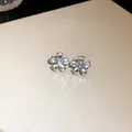 Detailed close-up view of elegant flower stud earrings with sparkling crystal petals and silver needle - Flower Stud Earrings / Silver