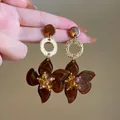 Detailed view of brown marbled resin flower earrings with amber crystal centers. - Brown