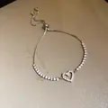 Close-up detail of a silver zircon heart pendant bracelet with adjustable slider clasp - Bracelet / Silver