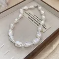 Close-up detail of a minimalist irregular baroque pearl necklace in a wooden jewelry box - Irregular Pearl Necklace / Large