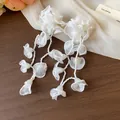 Close-up of elegant white chiffon flower tassel earrings with intricate bead details - White
