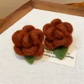 Detailed view of brown flocked flower earrings with green leaf accent - Rose Style / Brown
