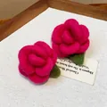 Detailed close-up view of pink flocked rose earrings with green leaves and silver needles - Rose Style / Rose Red