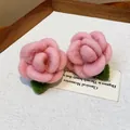 Detailed close-up of pink flocked rose earrings with green leaves on prop card. - Rose Style / Pink