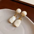 Macro view of vintage irregular resin earrings featuring marble texture and gold knotted links - Irregular Style (HE20012) / White