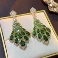 Detailed close-up of palace style earrings featuring green zircon tassels and gold setting - Style 5 Tassel