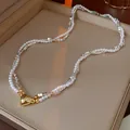 Macro detail van een elegante dubbellaagse parelketting met zilveren kralen en hart - 13# Ketting-Gouden Hart Dubbellaags / Zilver-Wit-Goud