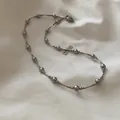 Detailopname van elegante zilveren kralenketting met grijze parels op stoffen achtergrond. - 15# Ketting-Grijze Kralen / Grijze Parel