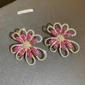 Close-up of vintage flower earrings with pink and white crystals on gold base - Blooming Flower Style