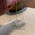 Detailopname van een zilveren ketting met strikhanger en een verfijnde slangenketting - 8# Ketting-Strik Slangenketting / Zilver