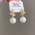 Primo piano di eleganti orecchini di perle d'oro con accenti di diamanti scintillanti in mostra - 25# Stile Strass Perla Vintage (Perno in Argento) / Oro