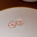 Close-up detail of pink cherry blossom earrings with golden edges and sparkly finish - Gold-Pink-Sakura