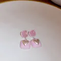 Detail of pink square drop earrings featuring a gold heart and translucent gemstones. - Gold-Pink-Heart Square