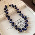 Detailed view of vintage navy blue resin bead necklace with intricate gold-tone metal links - Necklace / Blue/Gold
