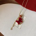 Close-up of a red flocked rocking horse necklace with golden chain and zircon details. - 2# Necklace-Gold Thin Metal Chain / Red